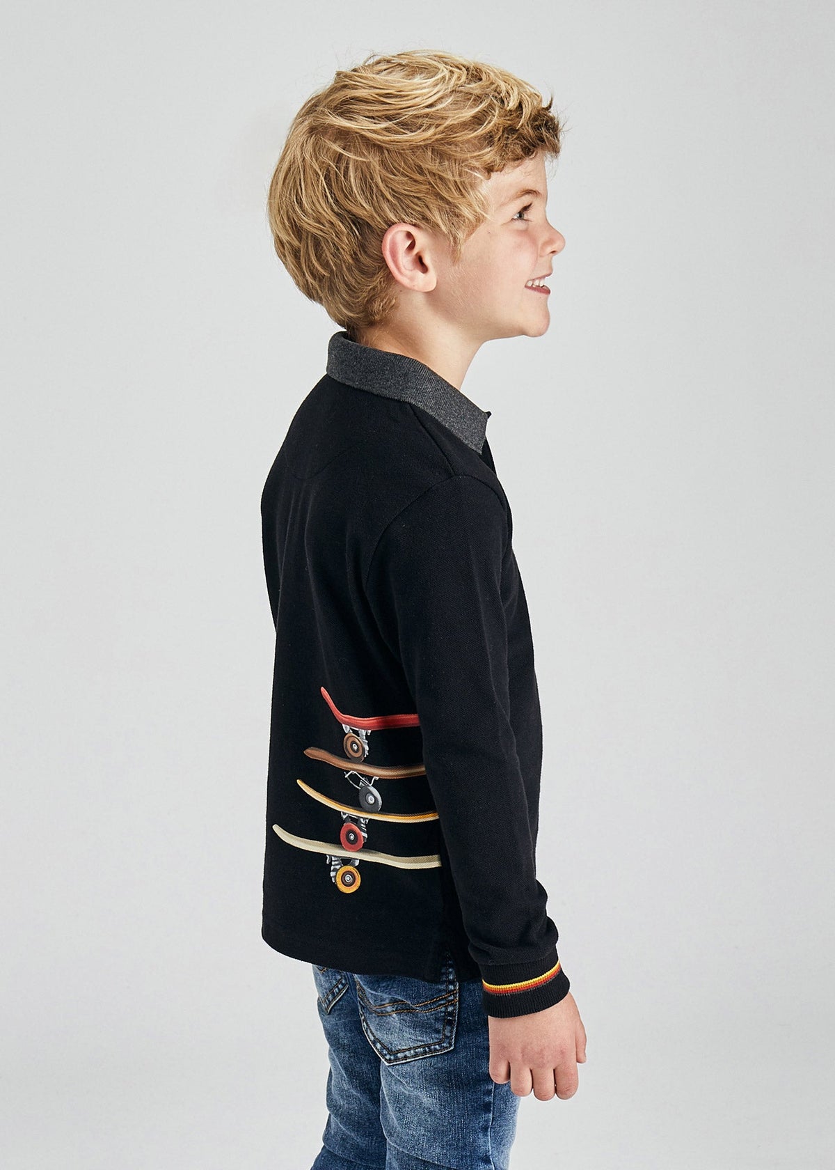 Boy wearing Mayoral black skater long sleeve polo shirt, side view