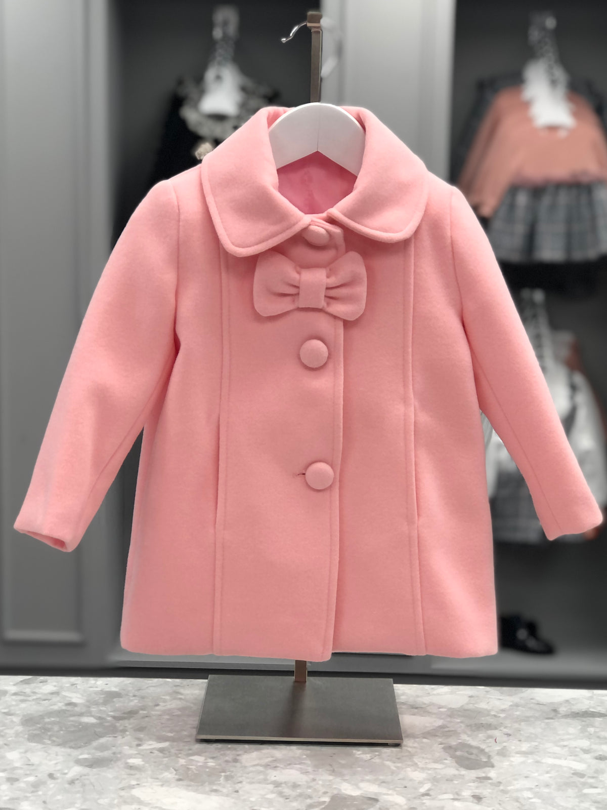 Eva Class Valeria girls soft pink coat front view with rounded collar, decorative bow and covered buttons