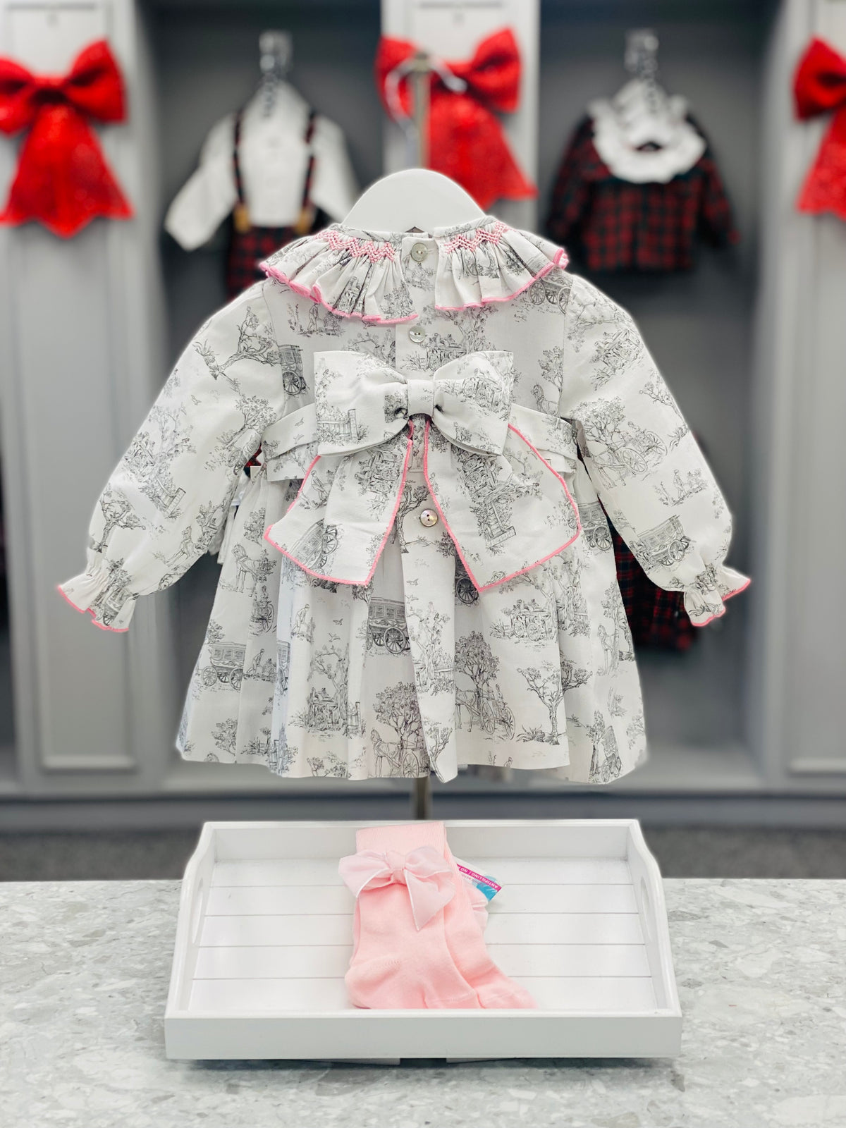 Naxos girls toile print hand smocked dress with large pink-trimmed bow and button fastening