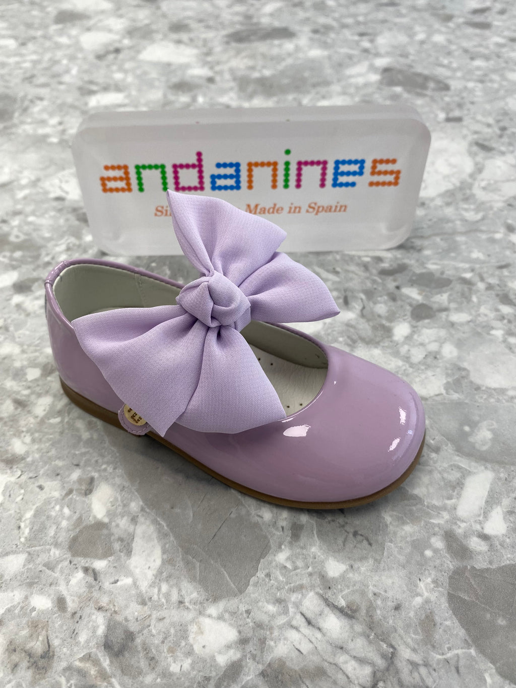Andanines lilac patent leather girls shoes with detachable chiffon bow and adjustable Velcro fastening, handcrafted in Spain