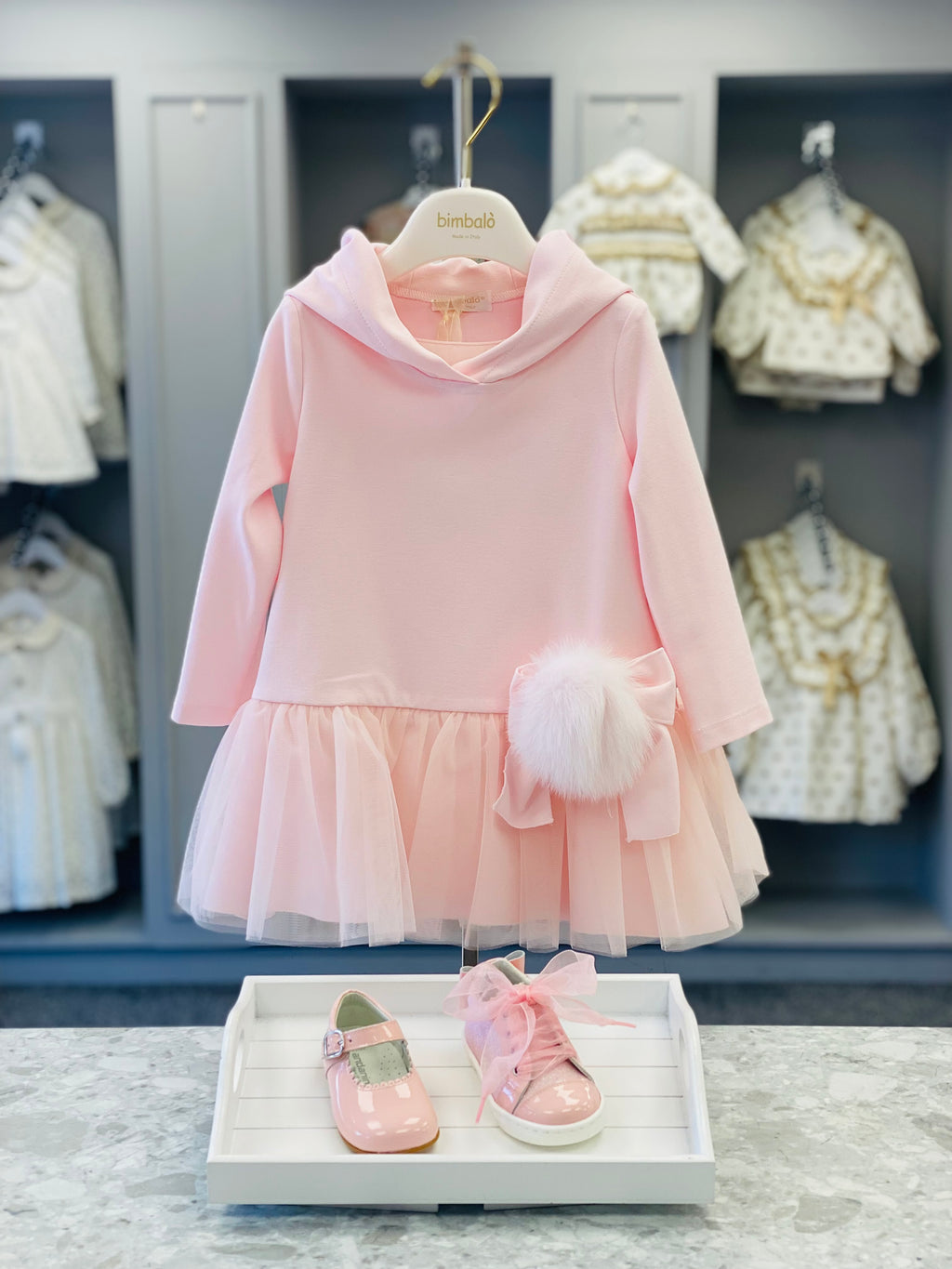Bimbalò girls pink hooded dress with tulle skirt, satin bow and faux fur pom pom detail.