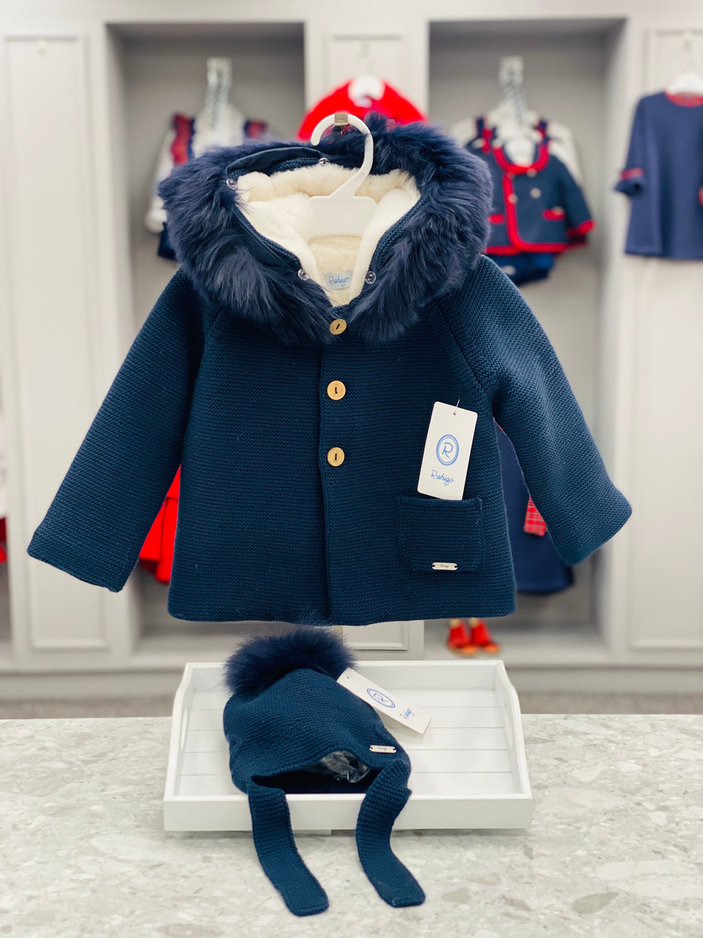Rahigo boys navy knitted coat with wooden buttons, front pockets and faux fur-trimmed hood