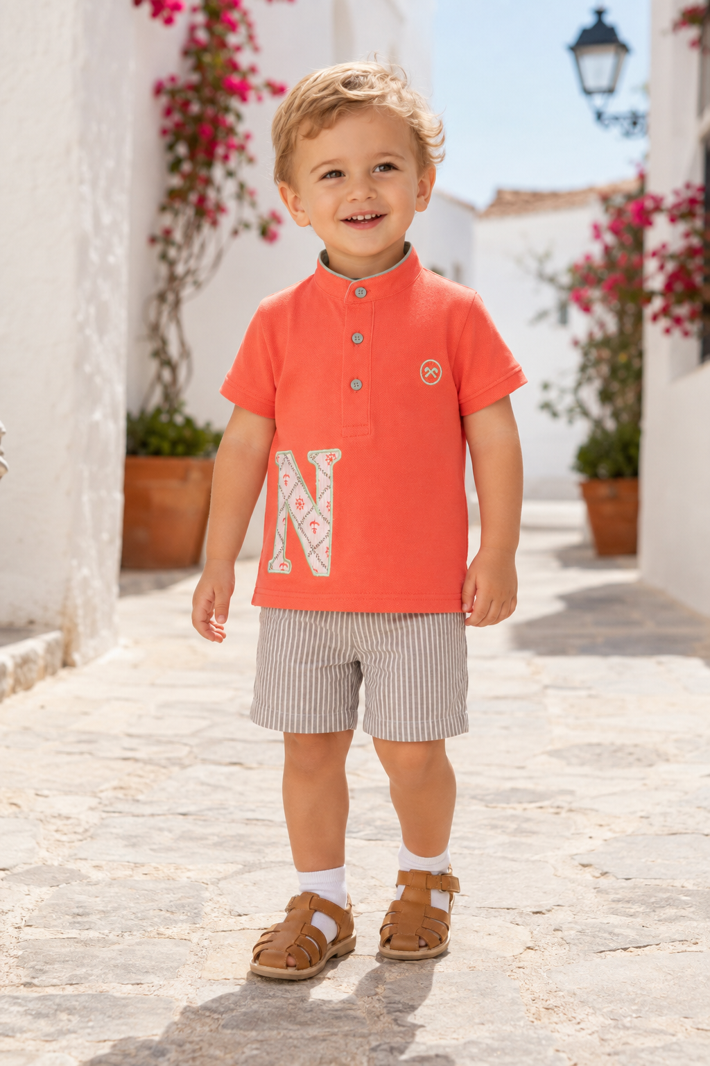 Little boy wearing Miranda Nel Blu Coral Boys T-Shirt with grandad collar, appliqué N detail and embroidered Miranda logo.
