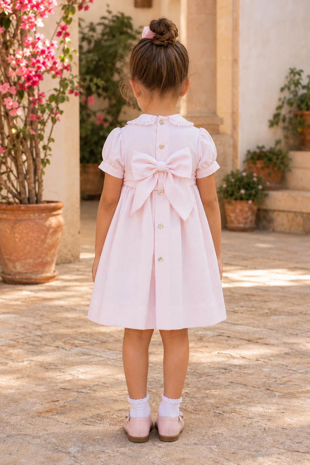 Back view of Naxos Hand Smocked Florinda Girls Pink Pique Cotton Dress showing the bow.