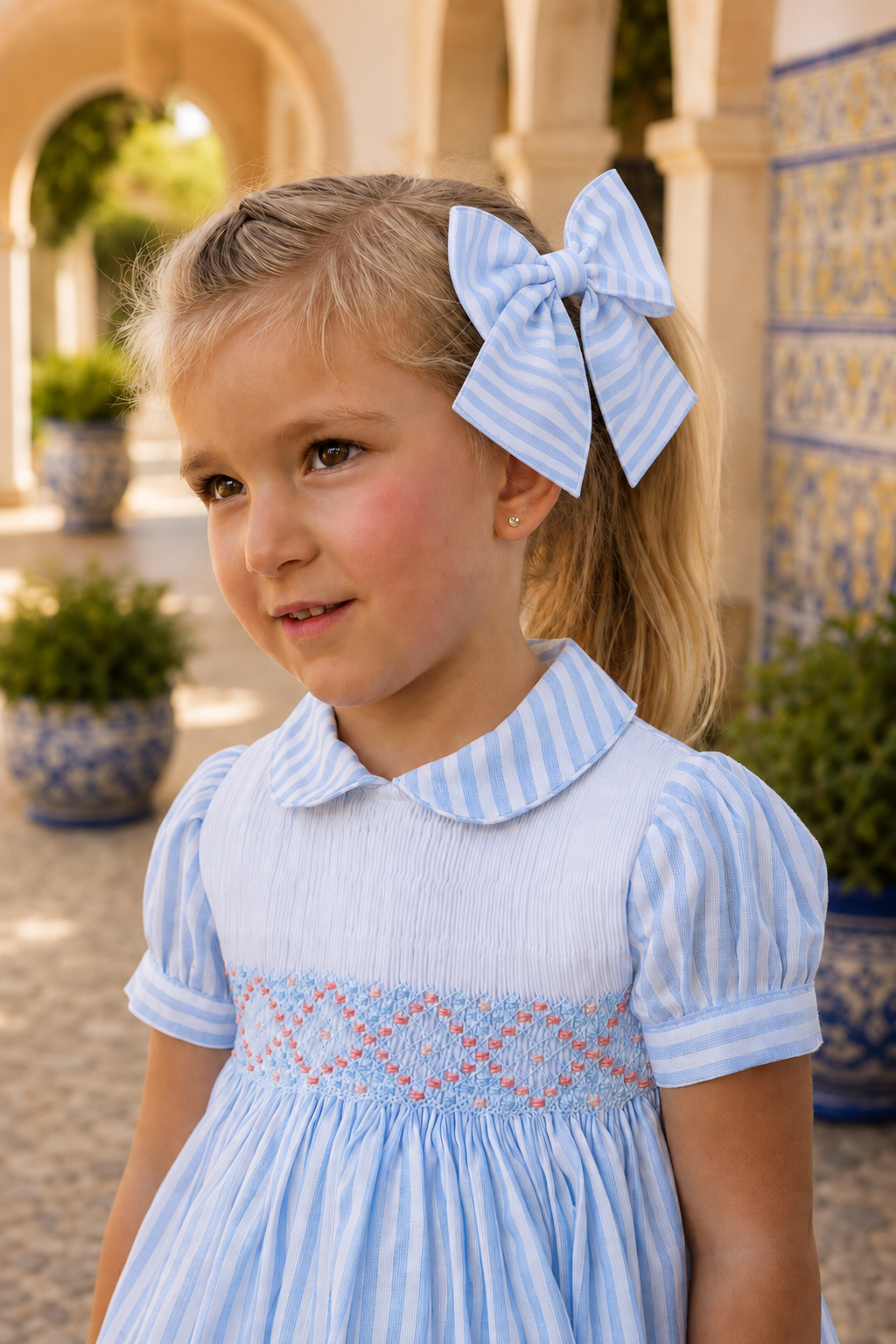 Girl wearing Naxos Carmen blue and white striped hair bow on metal clip.