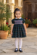 Naxos Escocia girls navy and green tartan hand smocked dress with white Peter Pan collar and puff sleeves.