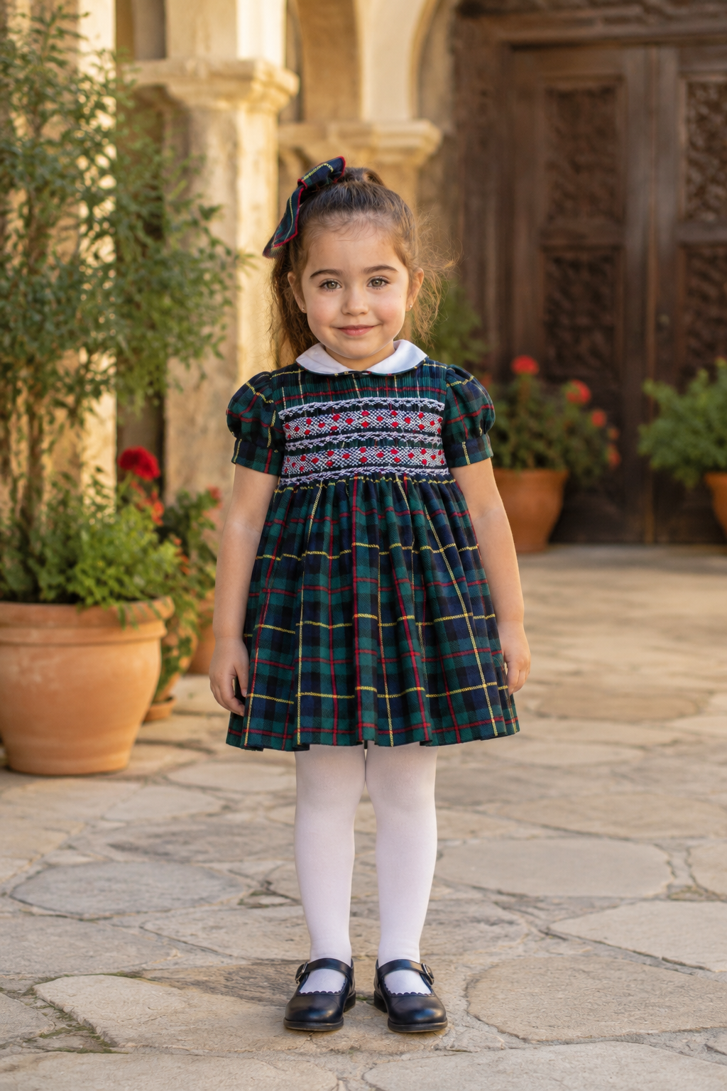 Naxos Escocia girls navy and green tartan hand smocked dress with white Peter Pan collar and puff sleeves.