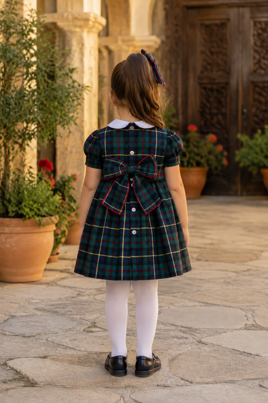 Naxos Escocia girls navy tartan dress with button fastening and large matching bow to the back.