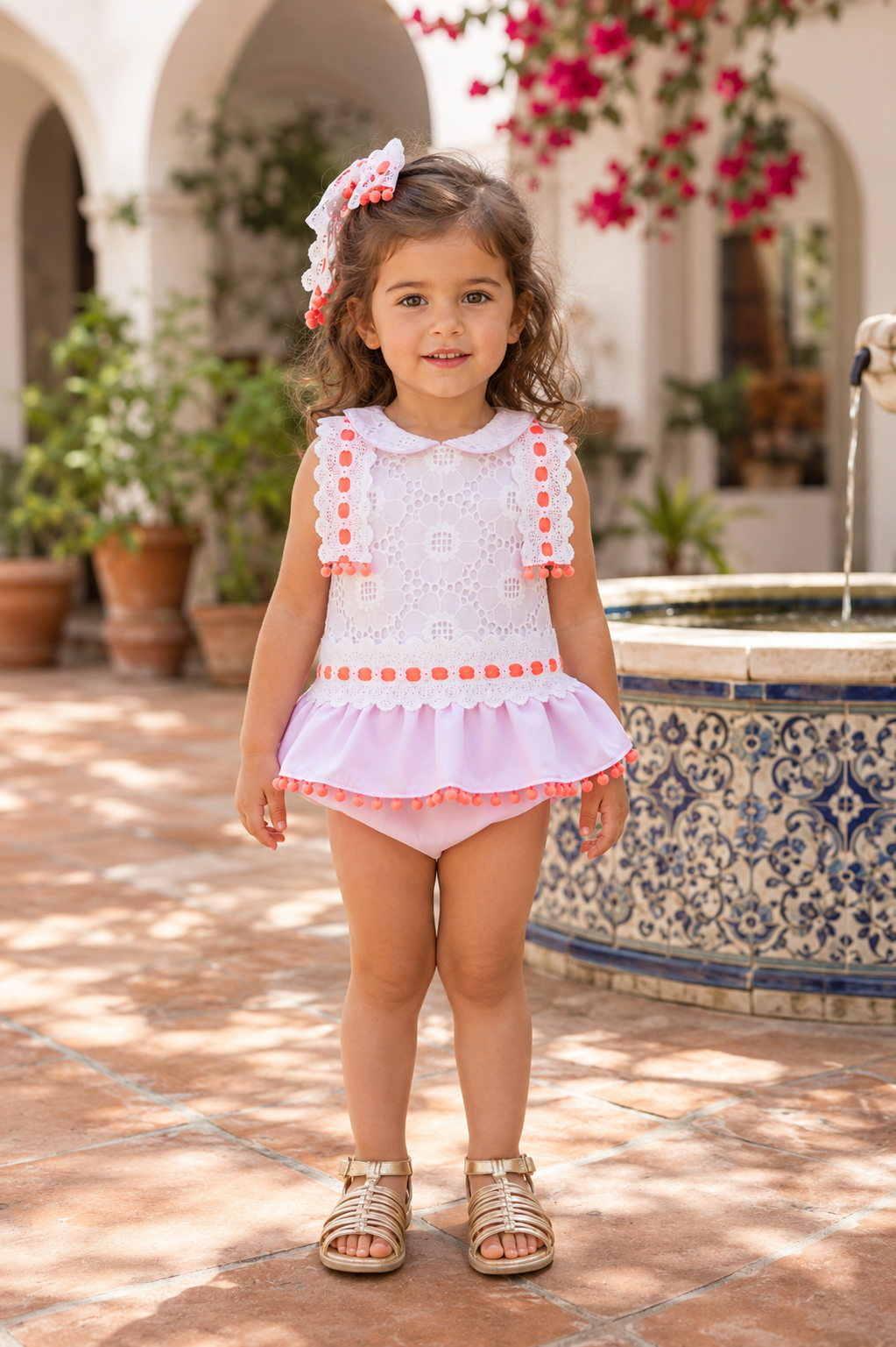 Naxos Neon girls pink and white lace dress and knickers with bright orange pom pom trim.