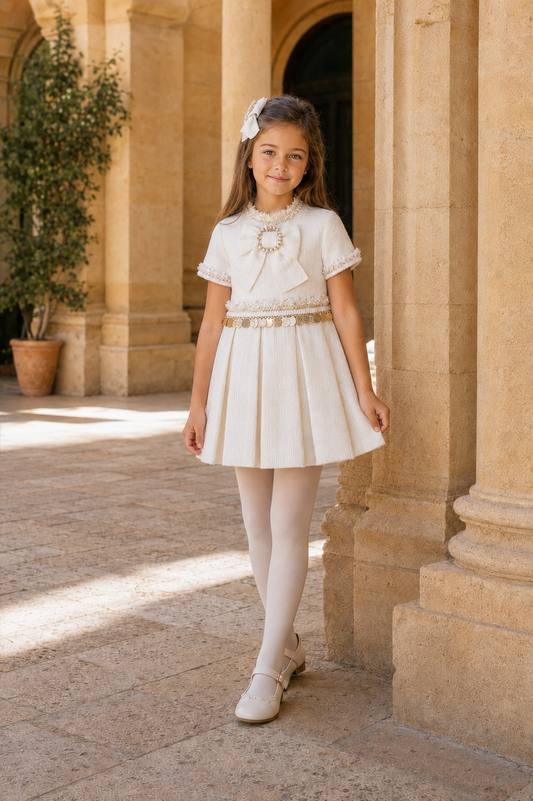 Girl wearing the Naxos cream and gold tweed dress in a Spanish courtyard