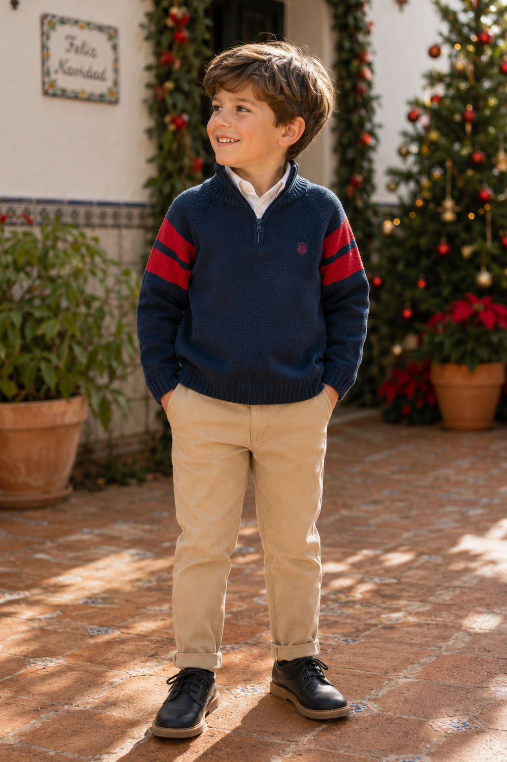 Boy wearing Tutto Piccolo navy and beige trouser set with jumper in Spain