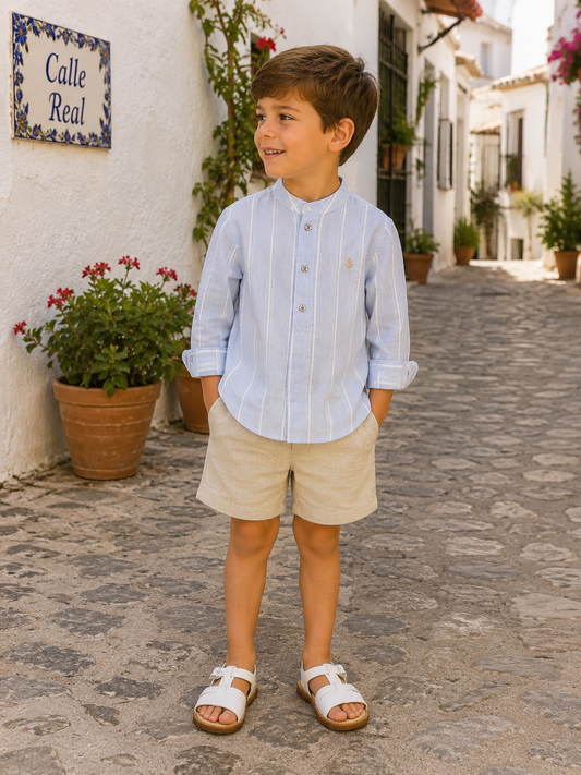 Boy wearing Tutto Piccolo Montpellier porcelain blue stripe shirt and beige linen shorts in Spain