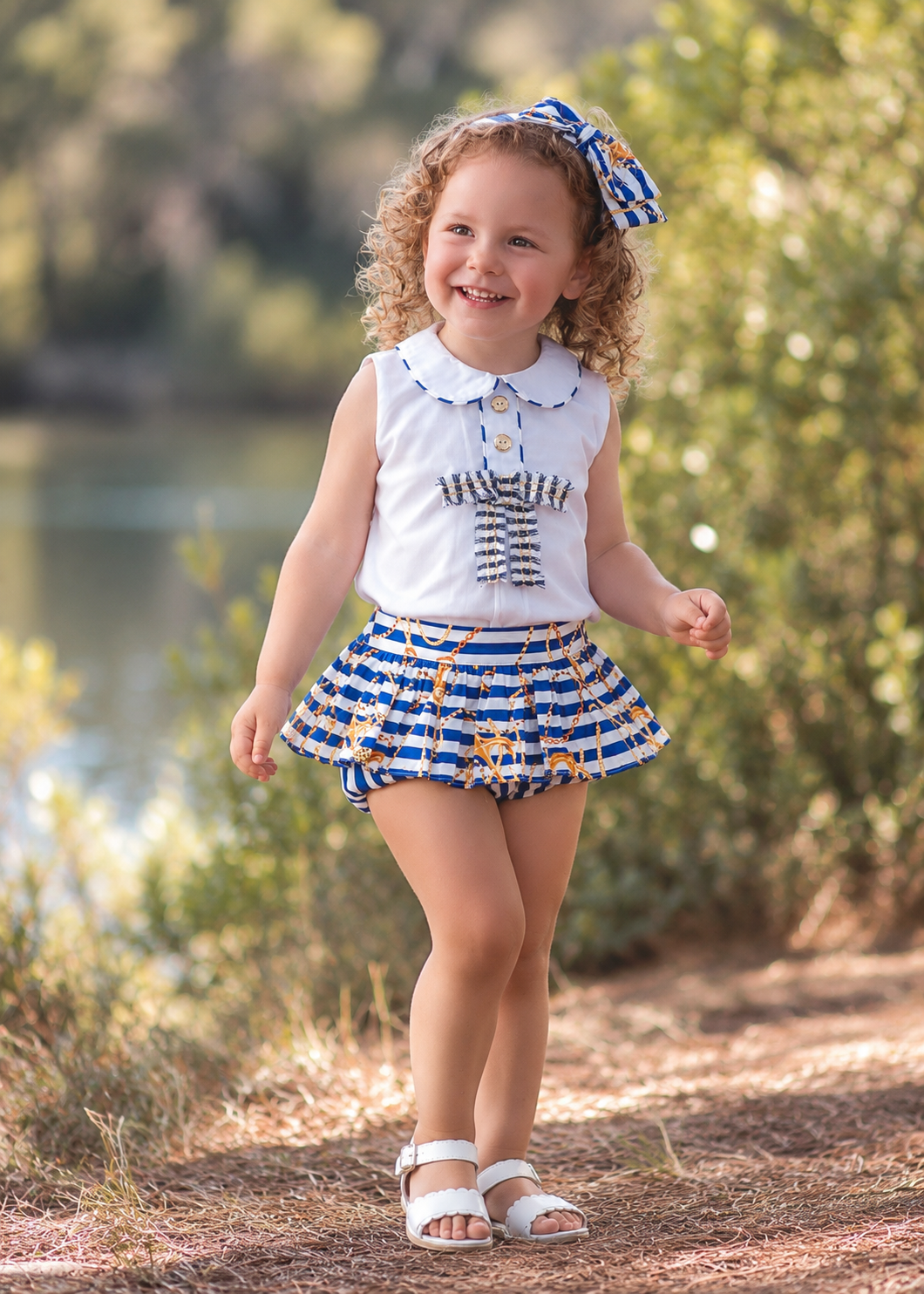Rochy Marine girls navy anchor jam pant set with white blouse, striped jam pants and matching bow headband outdoors