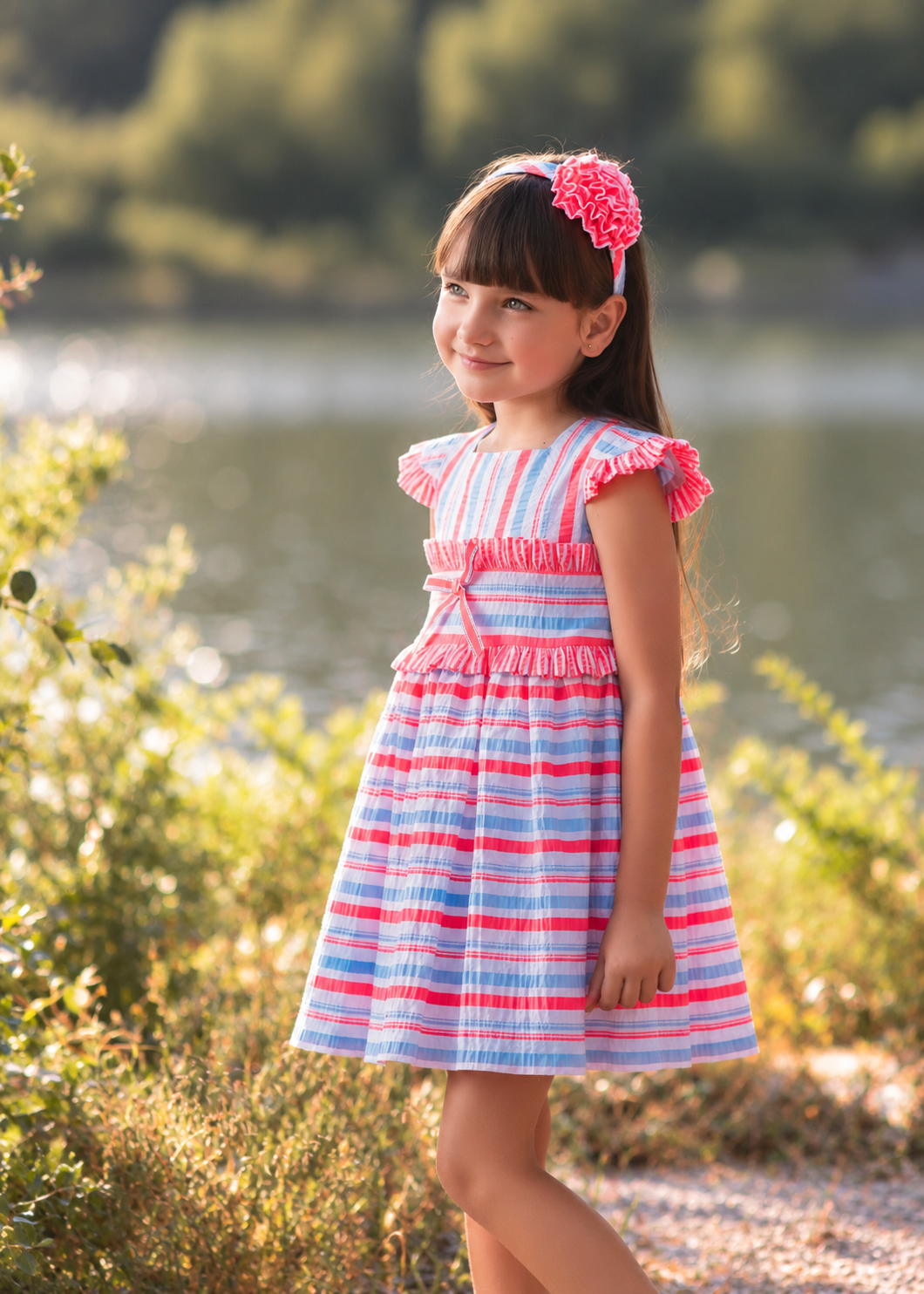 Rochy Fluor girls blue white and neon pink striped summer dress with ruffle detailing and bow & matching headband.