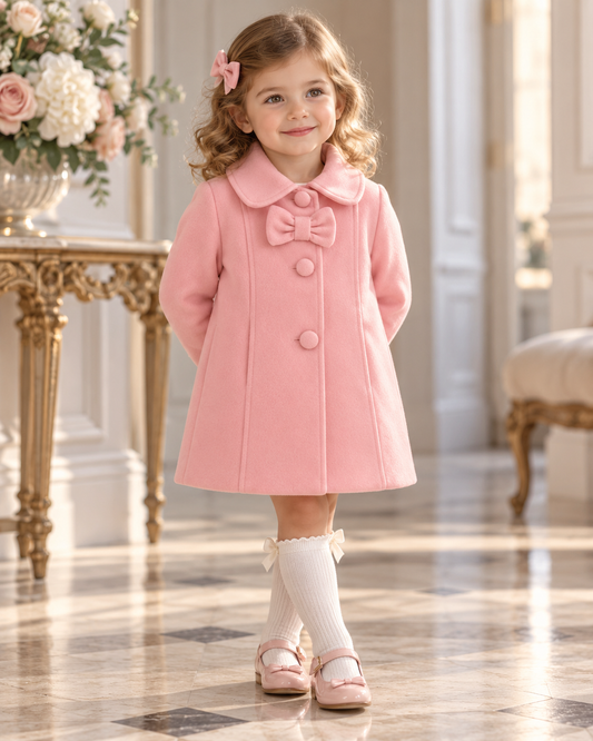 Eva Class Valeria girls pink traditional coat worn by a young girl, with Peter Pan collar, bow and covered buttons
