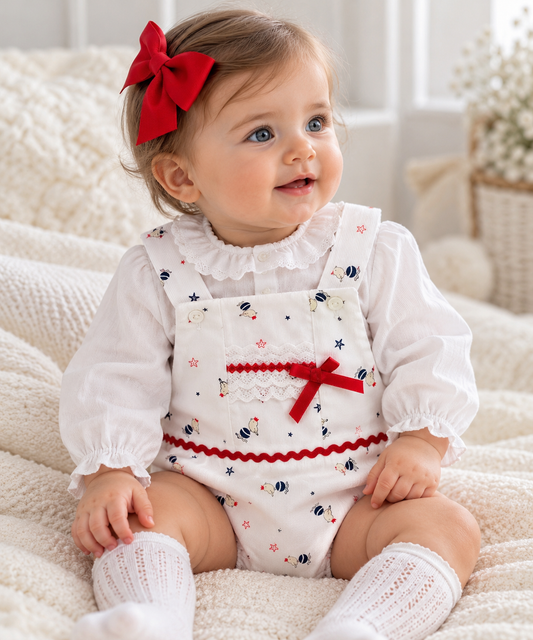 Eva Class Clara girls white bird print romper with red bow and lace detail, worn by a baby girl aged around 6 to 9 months over a white blouse