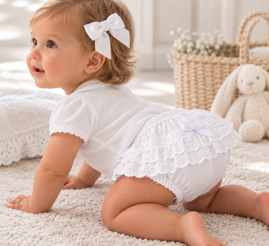 Miranda 75B white baby frilly knickers worn by a crawling baby, showing broderie anglaise ruffles and white bow at the back