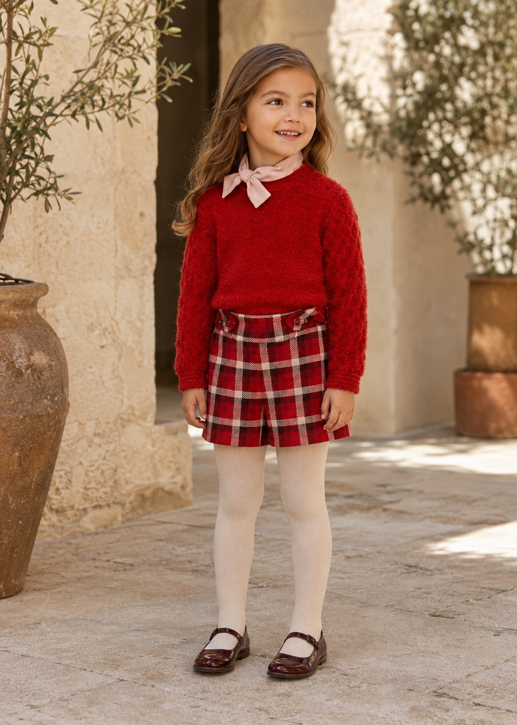 Girl wearing Abel & Lula red jumper, bow-neck top and plaid shorts - 5827
