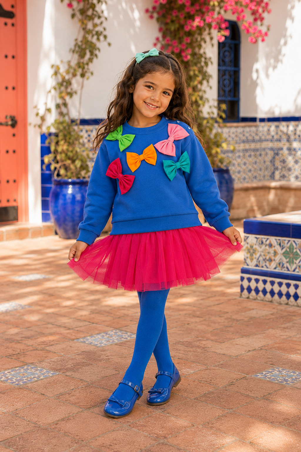 Spanish girl wearing the Agatha Ruiz de la Prada electric-blue bow top, fuchsia tulle skirt and blue tights
