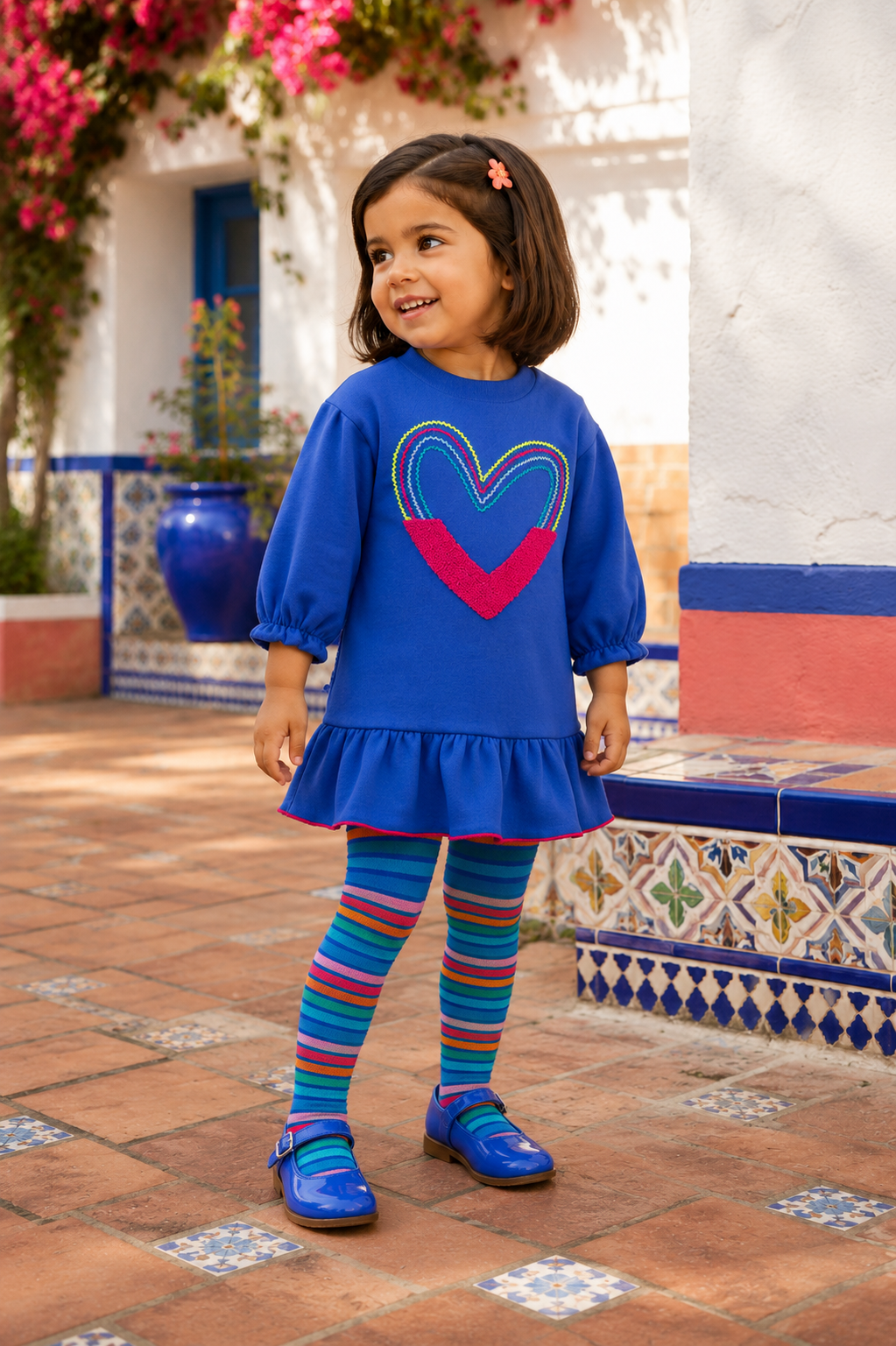 Spanish girl wearing the Agatha Ruiz de la Prada electric-blue heart dress with multicoloured striped tights