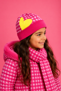 Spanish girl wearing the Agatha Ruiz de la Prada fuchsia check hat and scarf with matching coat