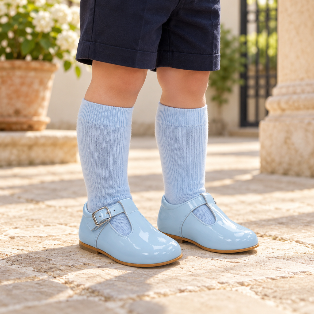 Boy wearing Andanines blue patent leather T-bar shoes with blue knee-high socks