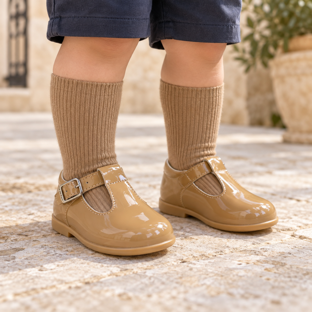 Andanines camel patent leather boys T-bar shoes worn with camel socks and navy shorts