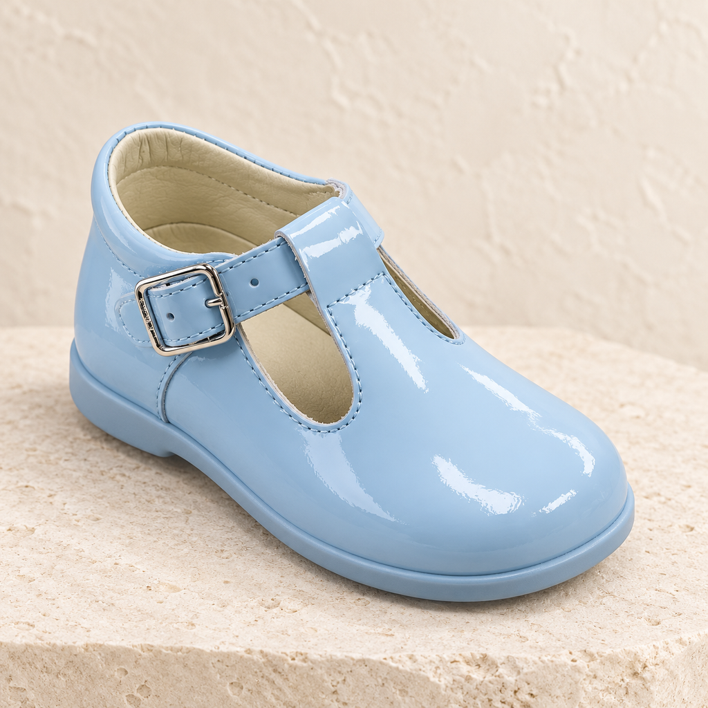 Andanines pale blue patent leather boys T-bar shoes with rubber sole on a warm ivory background