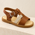 Andanines tan and beige leather boys sandal on a cream stone plinth