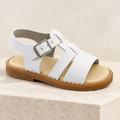 Andanines white leather boys sandal on a cream stone plinth