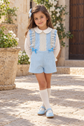 Girl wearing the Babine blue dogtooth playsuit and ivory plumeti blouse in Spain