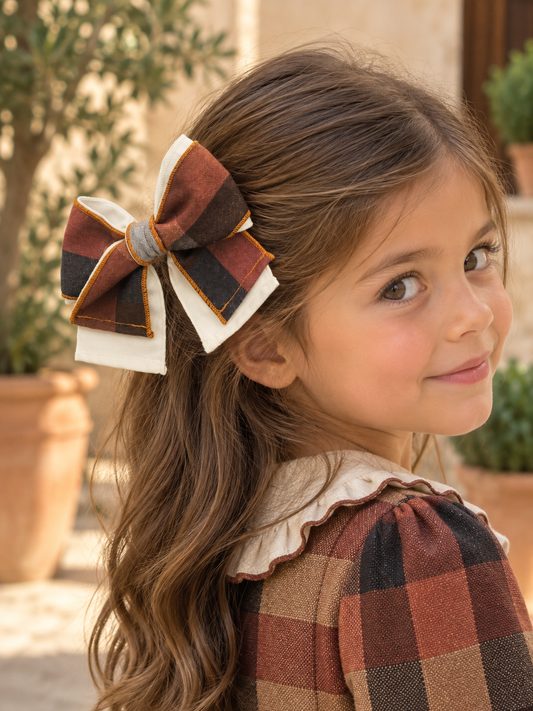 Girl wearing the Babine Calabaza camel and brown checked hair bow