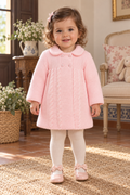 Baby girl wearing the Babine Canastilla pink knitted pram coat, front view