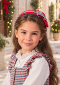 Girl wearing the Babine red check bow headband in a festive Spanish setting