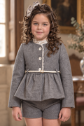Girl wearing the Babine Versailles grey peplum jacket with cream belt