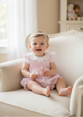 Baby girl wearing pink gingham romper in elegant setting