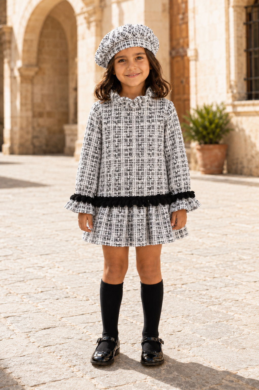Front view of girl wearing the Calamaro Alisio black and white tweed drop-waist dress
