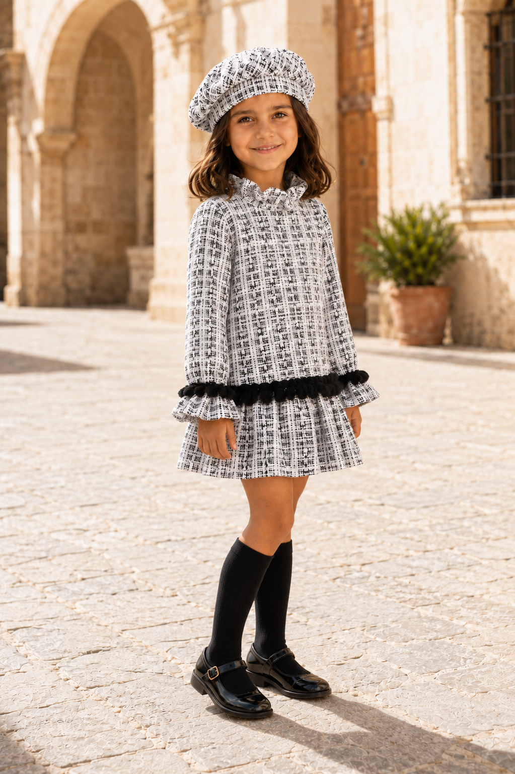 Three-quarter view of girl wearing the Calamaro Alisio black and white tweed dress