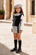 Three-quarter view of girl wearing the Calamaro Alisio black and white tweed skort set