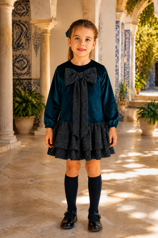 Girl wearing the CALAMARO Halny navy velvet and shimmer party dress in a Spanish courtyard