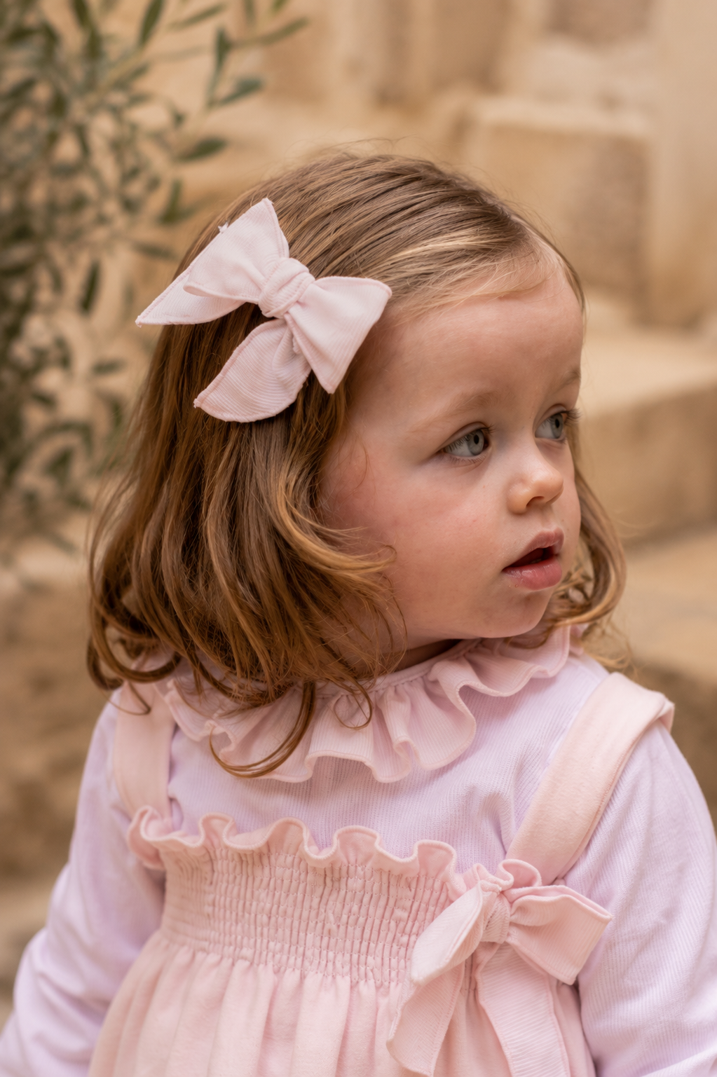 Calamaro Lebeche pale pink striped hair bow worn with matching pink outfit