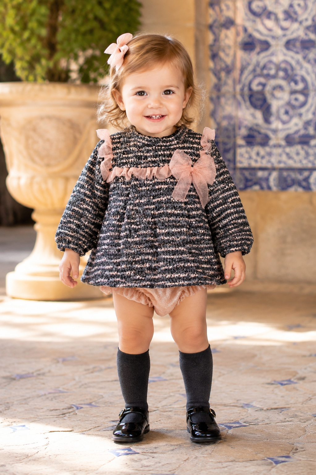 Toddler wearing the Calamaro Lips grey and pink tweed dress and knickers, front view