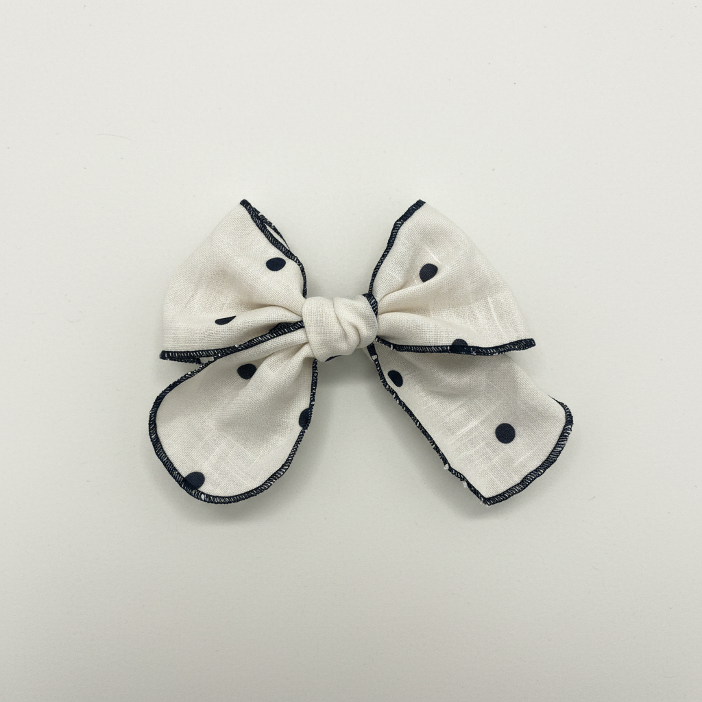 Cream and black polka dot hair bow flat lay