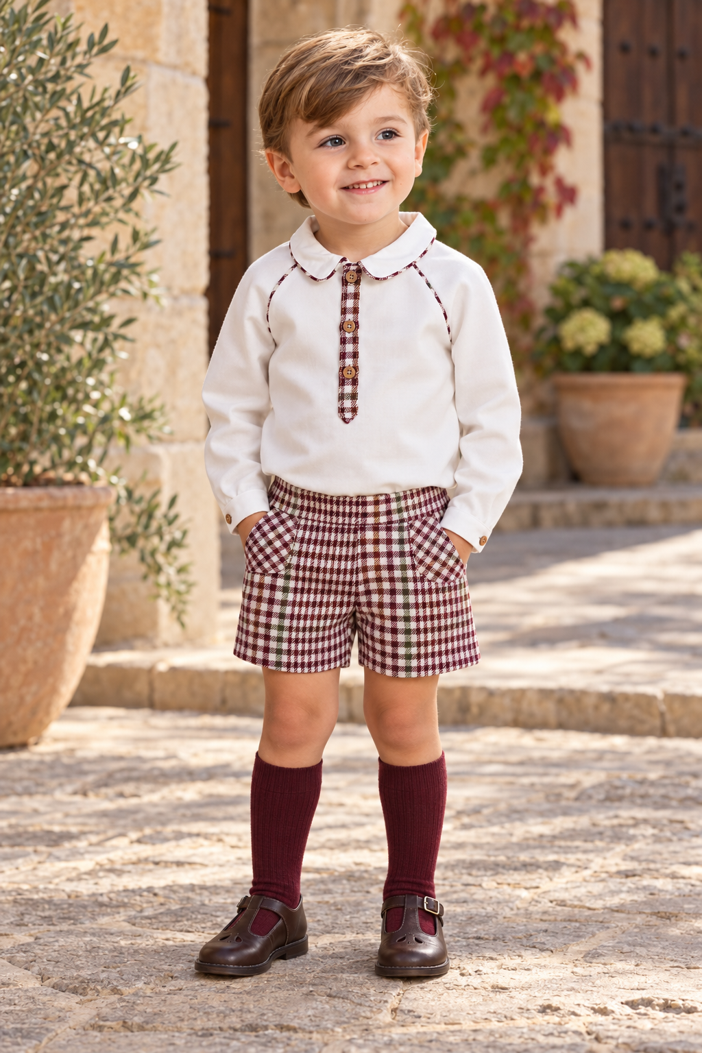 Boy wearing the Foque burgundy check short set with plain hem shorts in Spain