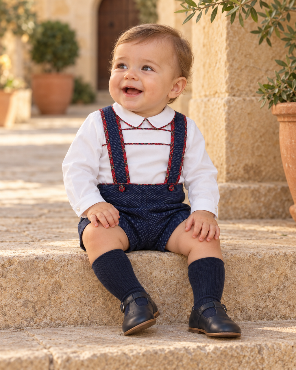 Foque Galletas boys navy and red tartan short set worn in a Spanish courtyard