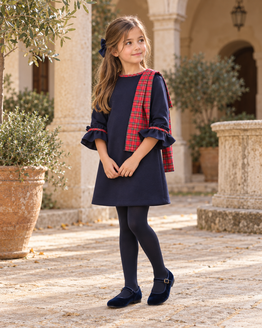 Foque Galletas girls navy tartan A-line dress worn in a Spanish courtyard