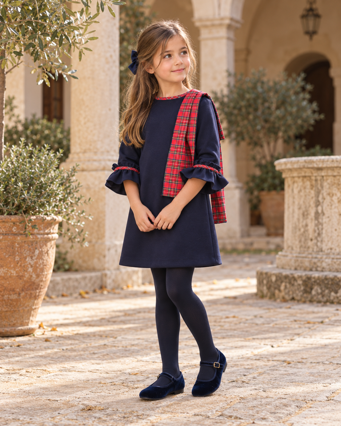 Foque Galletas girls navy tartan A-line dress worn in a Spanish courtyard