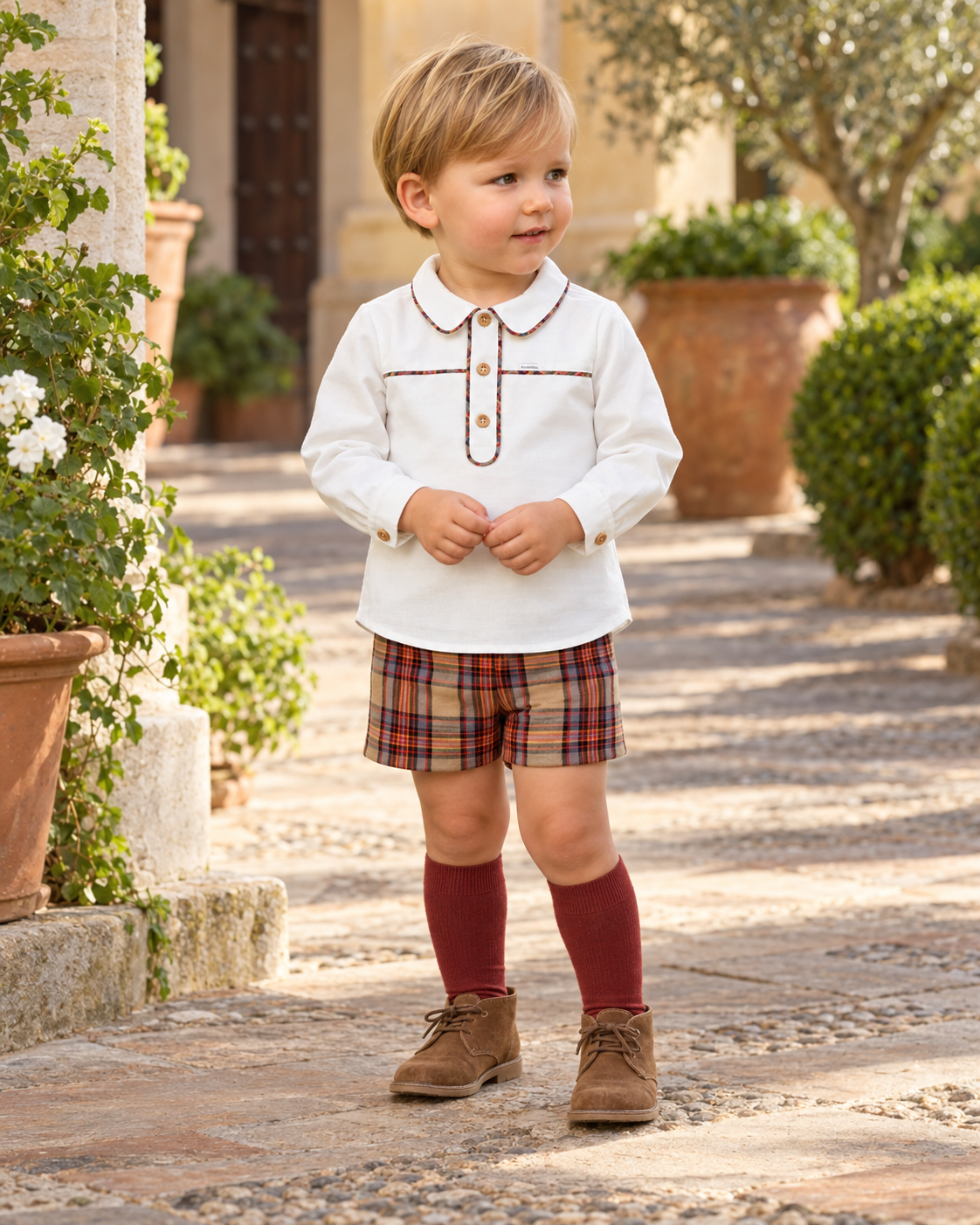 Boy wearing the Foque La Calabaza camel check short set in a Spanish courtyard
