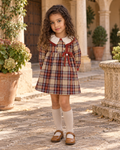 Girl wearing the Foque La Calabaza camel check dress in a Spanish courtyard