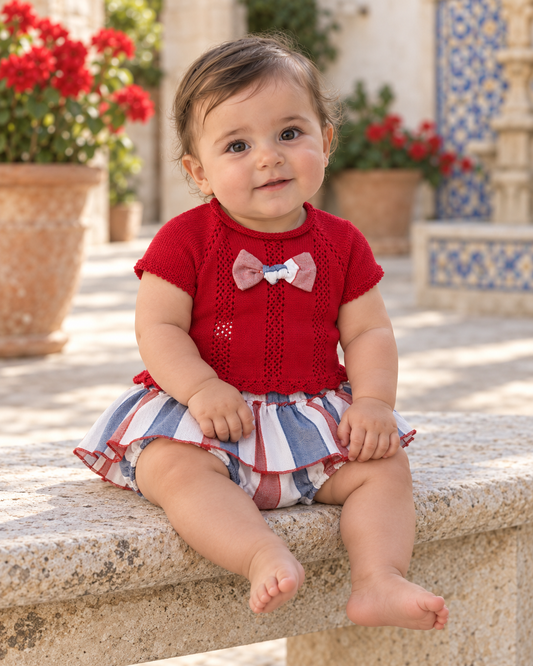 Baby girl wearing the Juliana Sandia red knitted top and striped peplum jam pant set in a Spanish courtyard